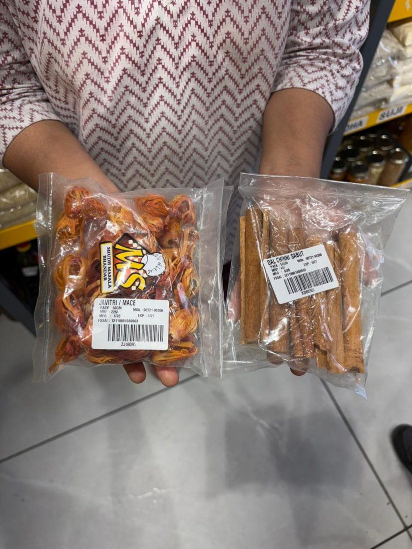 Mittal Spices ke labelled packs haath mein — Javitri aur Dal Chinni Sabut